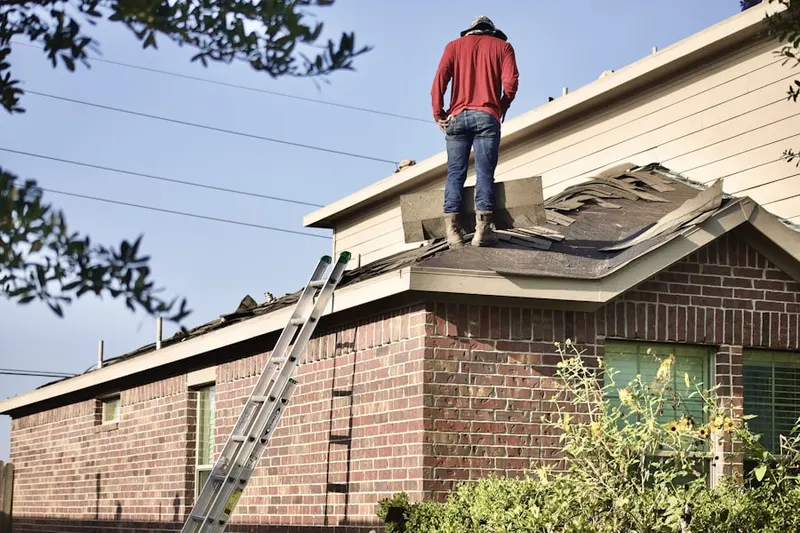 Professional roofer working on a residential roof in Clinton